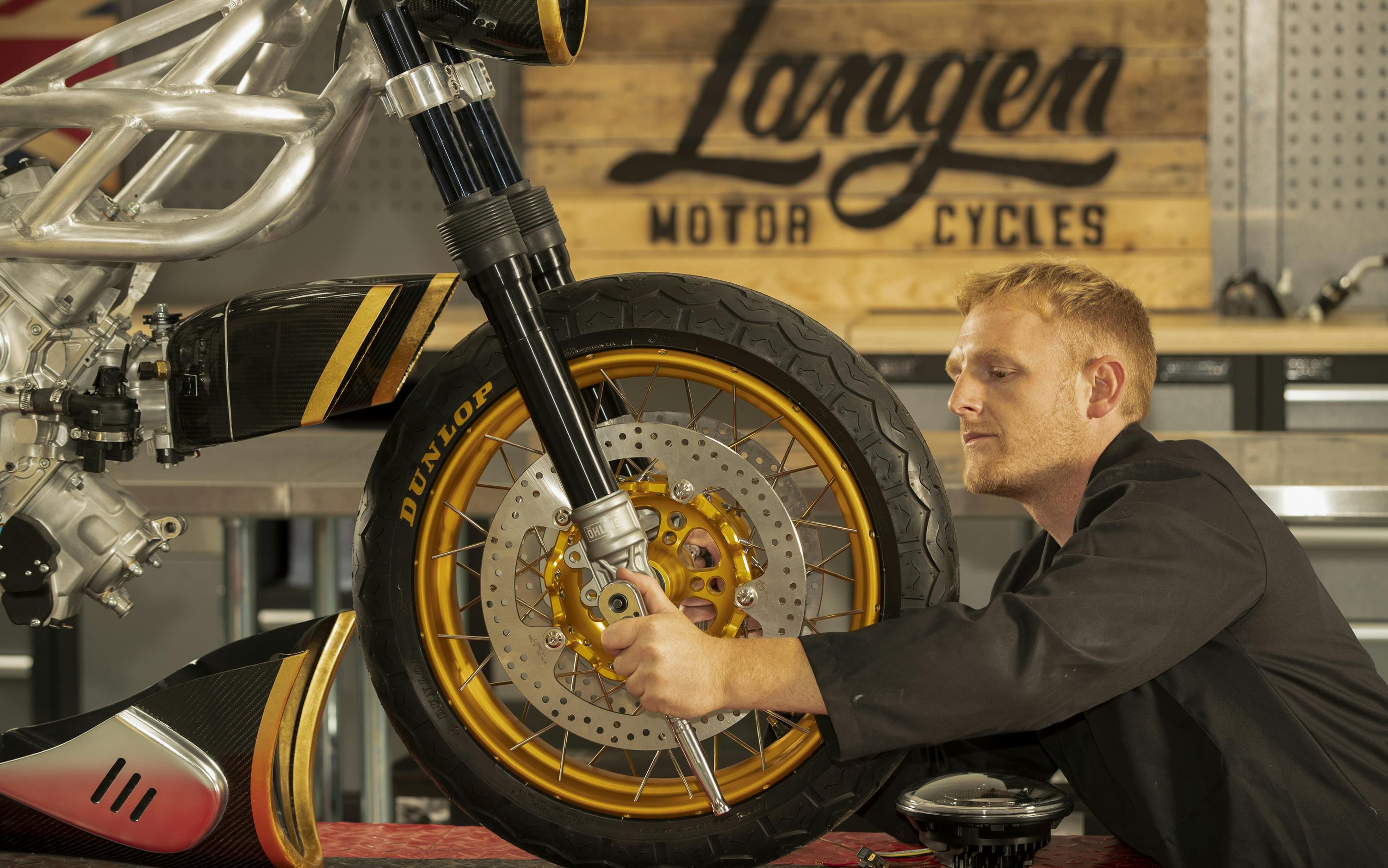 An engineer works on a motorcycle wheel